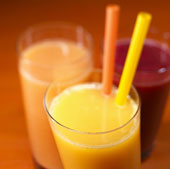 Orange juice with two straws, grapefruit juice & cherry juice